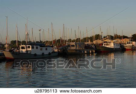 Stock Image - Boats docked at a harbor. Fotosearch