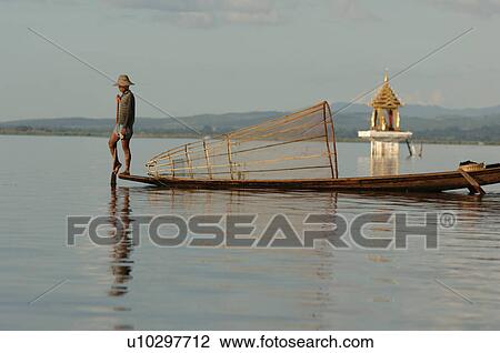 Stock Image - Fisherman in row boat. Fotosearch