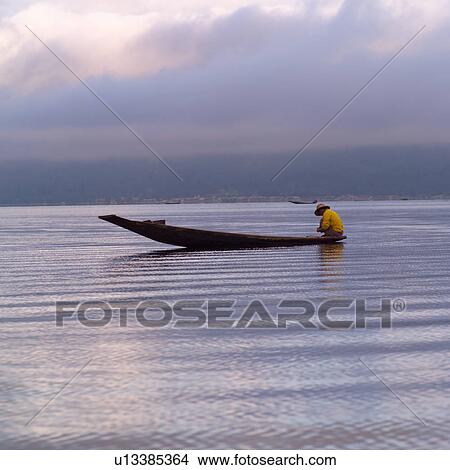 Intha fisherman in his flat-bottomed boat View Large Photo Image Picture - Intha fisherman in his flat-bottomed boat. Fotosearch