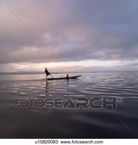 Stock Image - Intha fisherman in his flat-bottomed boat. Fotosearch