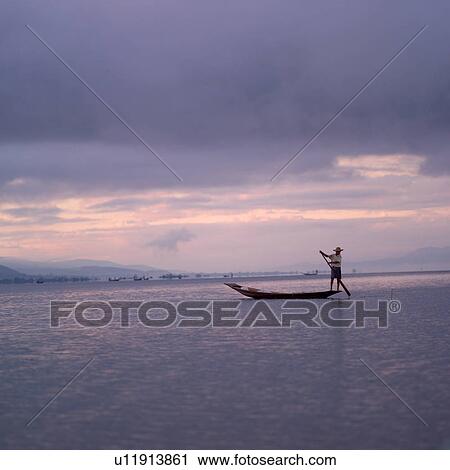 Stock Image - Intha fisherman in his flat-bottomed boat. Fotosearch