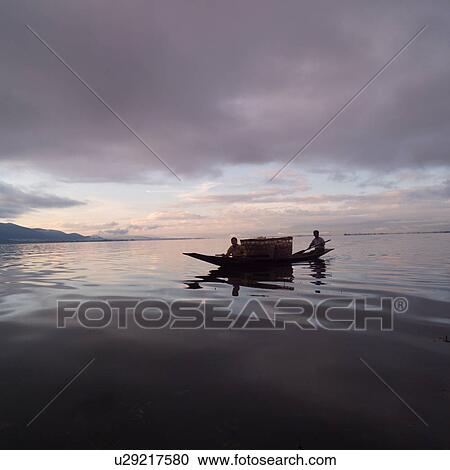 Stock Image - Intha fisherman in his flat-bottomed boat. Fotosearch