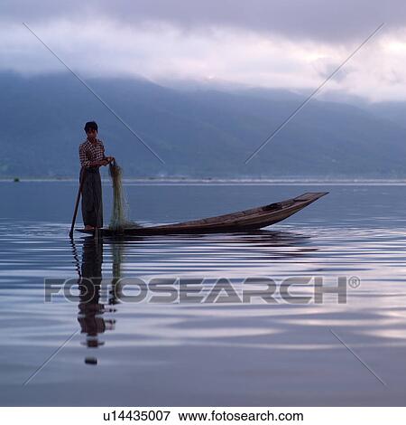 Stock Photo - Intha fisherman in his flat-bottomed boat. Fotosearch