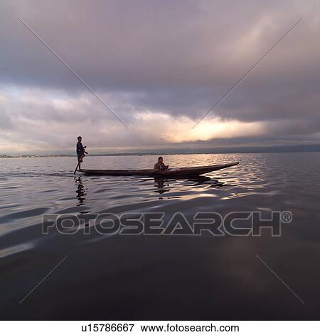 Intha fisherman in his flat-bottomed boat View Large Photo Image Stock Photo - Intha fisherman in his flat-bottomed boat. Fotosearch