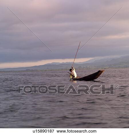 Stock Photo - Intha fisherman in his flat-bottomed boat. Fotosearch