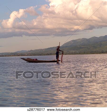 Intha fisherman in his flat-bottomed boat View Large Photo Image Stock Photo - Intha fisherman in his flat-bottomed boat. Fotosearch