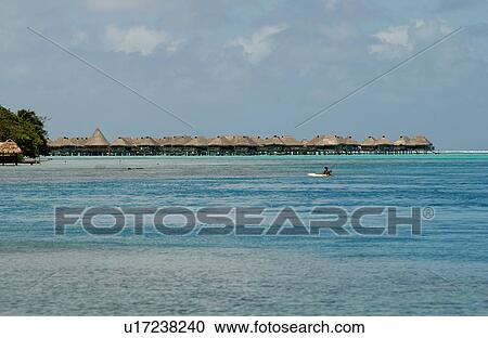 Stock Image - Panoramic view of thatched buildings on stilts in the sea, Moorea, Tahiti, French Polynesia, South Pacific. Fotosearch