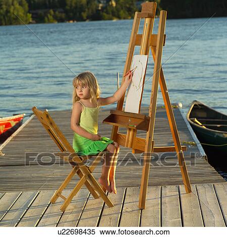 Stock Photography - 4 year old sitting at an easel. Fotosearch