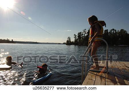 6 year old girl standing on a dock in a lifejacket View Large Photo Image Stock Photo - 6 year old girl standing on a dock in a lifejacket. Fotosearch