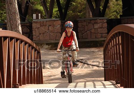 Child going over a bridge on a bike View Large Photo Image Picture - Child going over a bridge on a bike. Fotosearch
