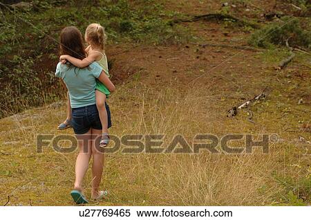 Girl carrying child down path View Large Photo Image Stock Photography - Girl carrying child down path. Fotosearch