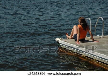 Girl sitting at edge of dock View Large Photo Image Stock Photograph - Girl sitting at edge of dock. Fotosearch