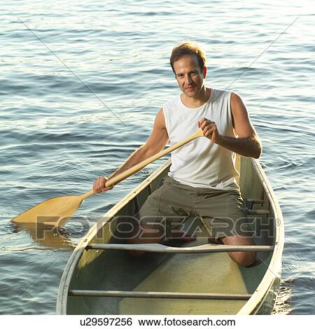 Stock Photograph - Man rowing a canoe. Fotosearch