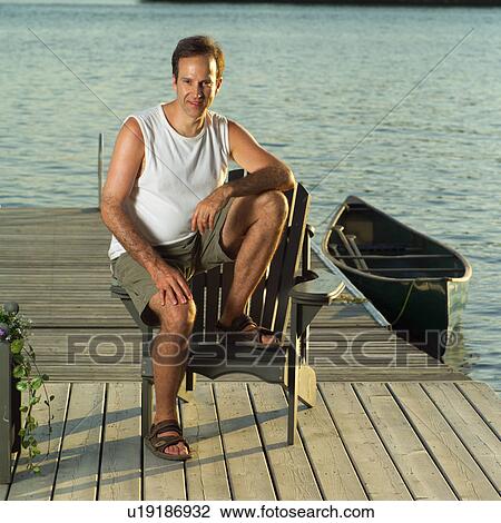 Man sitting on a chair outdoors View Large Photo Image Stock Image - Man sitting on a chair outdoors. Fotosearch