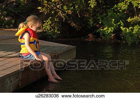 One girl dangling her feet in the water View Large Photo Image Stock Photograph - One girl dangling her feet in the water. Fotosearch