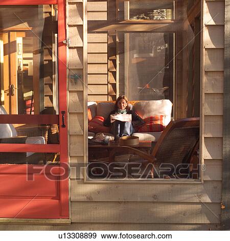 Woman relaxing on a sofa taken through a window View Large Photo Image Stock Photo - Woman relaxing on a sofa taken through a window. Fotosearch