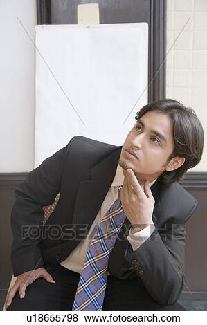 Businessman sitting in front of a whiteboard and thinking View Large Photo Image Stock Photo - Businessman sitting in front of a whiteboard and thinking. Fotosearch