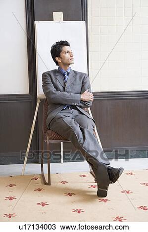 Stock Image - Businessman sitting on a chair and thinking. Fotosearch