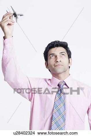 Picture - Close-up of a businessman holding a model airplane. Fotosearch