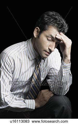 Stock Image - Close-up of a businessman suffering from a headache. Fotosearch