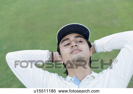 Close-up of a young man with his hands behind his head View Large Photo Image Stock Photography - Close-up of a young man with his hands behind his head. Fotosearch