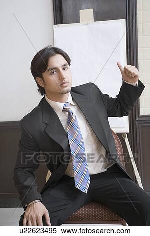 Portrait of a businessman sitting and showing a thumbs up sign View Large Photo Image Stock Photography - Portrait of a businessman sitting and showing a thumbs up sign. Fotosearch
