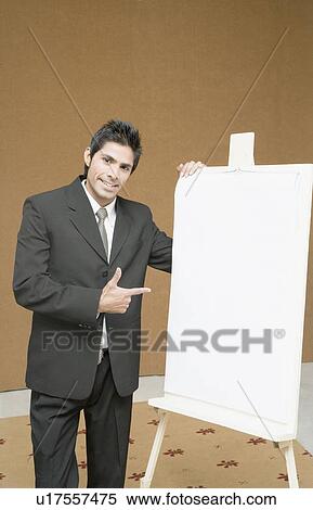 Stock Photography - Portrait of a businessman standing near a whiteboard and pointing. Fotosearch