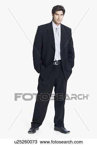 Stock Image - Portrait of a businessman standing with his hands in his pockets. Fotosearch