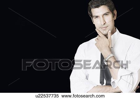 Portrait of a businessman standing with his hand on his chin View Large Photo Image Stock Photography - Portrait of a businessman standing with his hand on his chin. Fotosearch