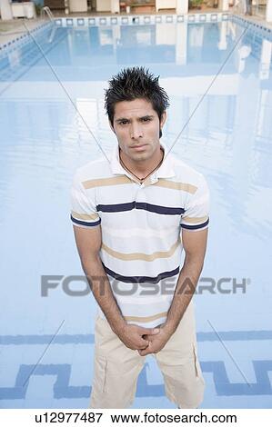 Portrait of a young man standing in front of a swimming pool View Large Photo Image Stock Photo - Portrait of a young man standing in front of a swimming pool. Fotosearch