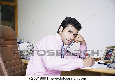 Stock Image - Side profile of a businessman talking on the telephone. Fotosearch