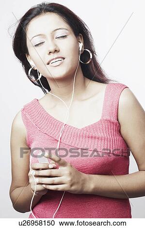 Stock Image - Close-up of a young woman listening to an MP3 player. Fotosearch