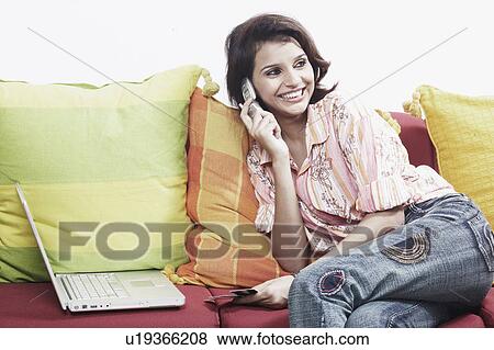 Close-up of a young woman on the telephone holding a credit card View Large Photo Image Stock Photo - Close-up of a young woman on the telephone holding a credit card. Fotosearch