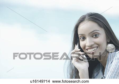 Portrait of a teenage girl talking on a mobile phone View Large Photo Image Picture - Portrait of a teenage girl talking on a mobile phone. Fotosearch