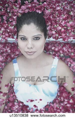 Portrait of a young woman in a swimming pool filled with rose petals View Large Photo Image Stock Photo - Portrait of a young woman in a swimming pool filled with rose petals. Fotosearch