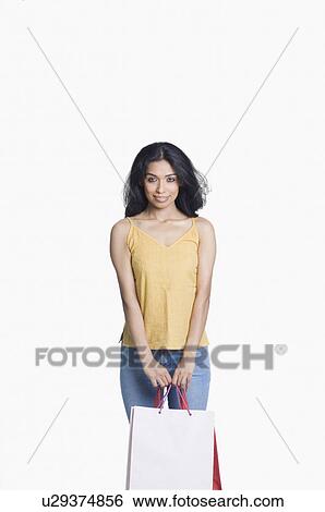 Portrait of a young woman standing with two shopping bags View Large Photo Image Stock Photograph - Portrait of a young woman standing with two shopping bags. Fotosearch