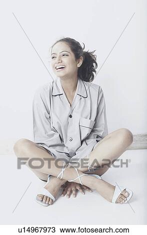 Young woman sitting with her legs crossed View Large Photo Image Stock Image - Young woman sitting with her legs crossed. Fotosearch
