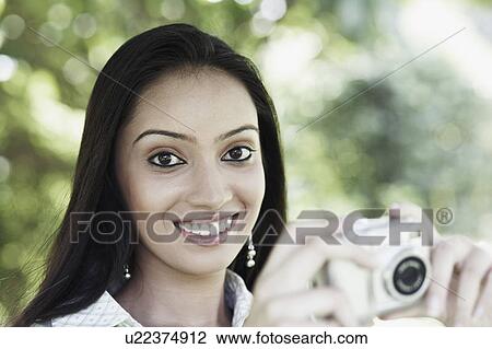Portrait of a teenage girl holding a digital camera View Large Photo Image Stock Image - Portrait of a teenage girl holding a digital camera. Fotosearch