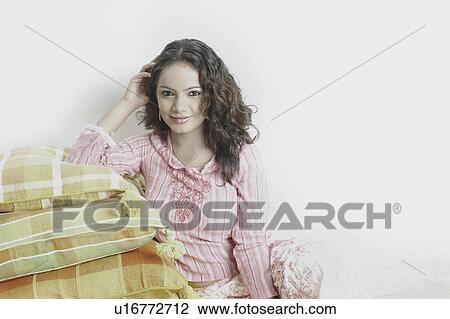 Portrait of a young woman leaning on cushions View Large Photo Image Stock Image - Portrait of a young woman leaning on cushions. Fotosearch