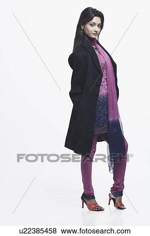 Stock Photo - Portrait of a young woman standing with her hands in her pockets. Fotosearch