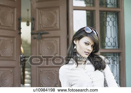 Portrait of a young woman with sunglasses on her head View Large Photo Image Stock Photo - Portrait of a young woman with sunglasses on her head. Fotosearch