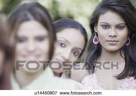 Portrait of two young women and a teenage girl standing in a row View Large Photo Image Stock Photo - Portrait of two young women and a teenage girl standing in a row. Fotosearch