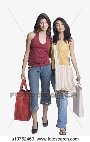 Portrait of two young women holding shopping bags and smiling View Large Photo Image Stock Photo - Portrait of two young women holding shopping bags and smiling. Fotosearch