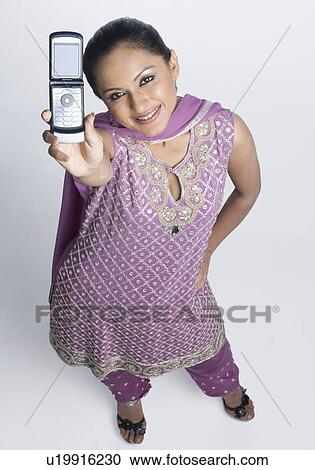High angle view of a mid adult woman standing in salwar kameez and holding a mobile phone View Large Photo Image Stock Image - High angle view of a mid adult woman standing in salwar kameez and holding a mobile phone. Fotosearch