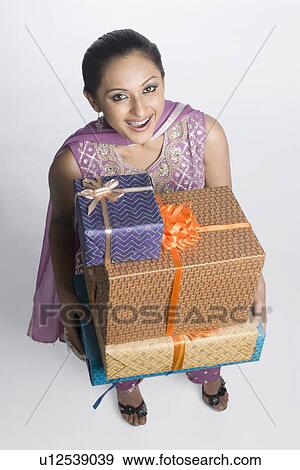 High angle view of a mid adult woman holding a stack of gift boxes View Large Photo Image Stock Photo - High angle view of a mid adult woman holding a stack of gift boxes. Fotosearch