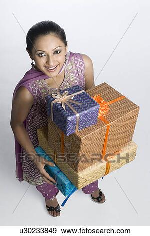 High angle view of a mid adult woman holding a stack of gift boxes View Large Photo Image Stock Photo - High angle view of a mid adult woman holding a stack of gift boxes. Fotosearch