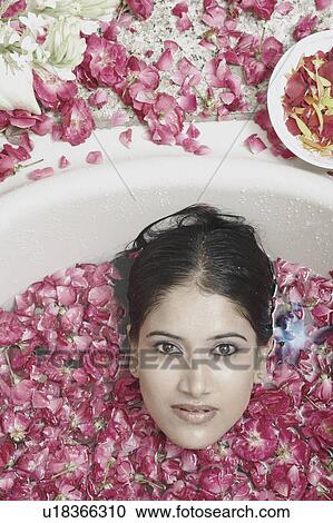 High angle view of a young woman lying in a bathtub covered with flower petals View Large Photo Image Stock Image - High angle view of a young woman lying in a bathtub covered with flower petals. Fotosearch