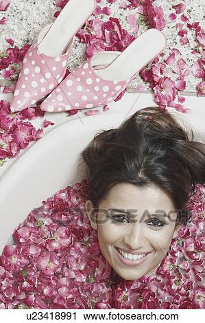 High angle view of a young woman lying in a bathtub covered with flower petals View Large Photo Image Stock Image - High angle view of a young woman lying in a bathtub covered with flower petals. Fotosearch