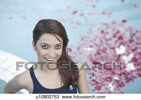 High angle view of a young woman standing in a swimming pool filled with flower petals View Large Photo Image Stock Image - High angle view of a young woman standing in a swimming pool filled with flower petals. Fotosearch