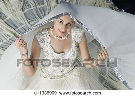 Stock Photo - High angle view of a young woman sitting in lehenga choli. Fotosearch